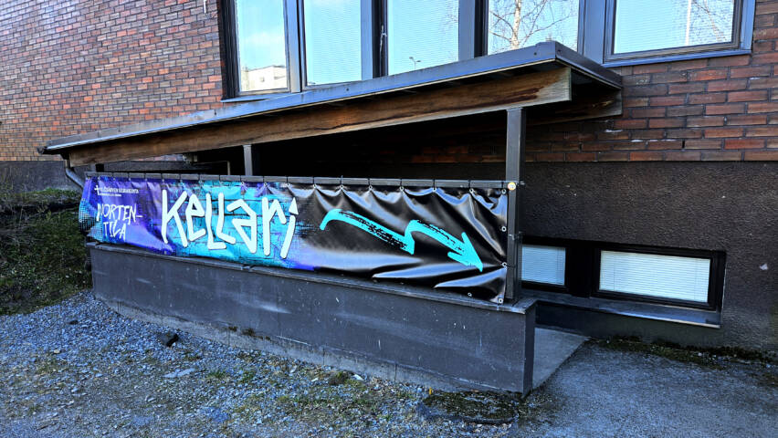 Nuorisotila Kellarin sisäänkäynnillä olevat portaat ja kaiteeseen kiinnitetty Kellari-banderolli.